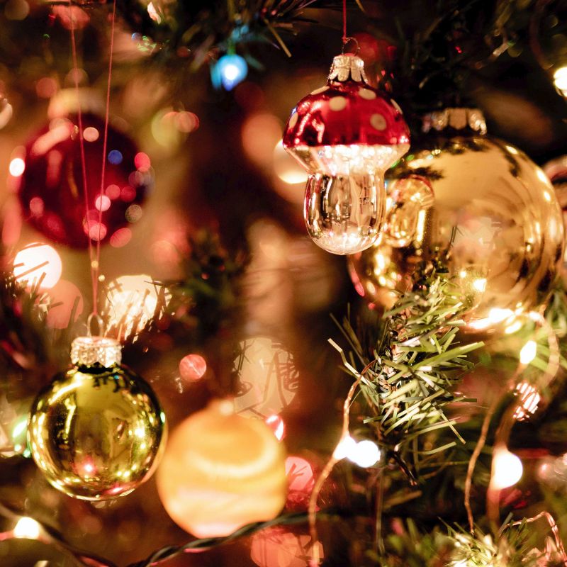 Christmas baubles and lights hanging from a Christmas tree.